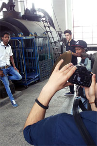 In einem Industriegebäude posiert ein junger Mann und wird fotografiert.