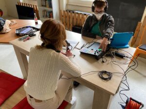 Zweei Jugendliche sitzen mit Laptop und Mischpult am Tisch