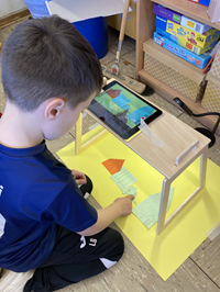 Sprache und Medien: Kind kniet vor Tablet